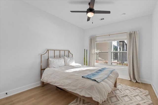 bedroom with light hardwood / wood-style floors and ceiling fan