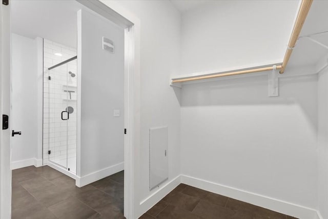 walk in closet featuring dark tile patterned floors