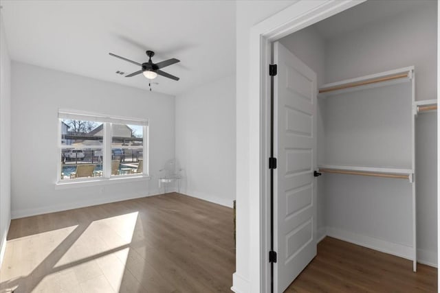 interior space featuring dark wood-type flooring and ceiling fan