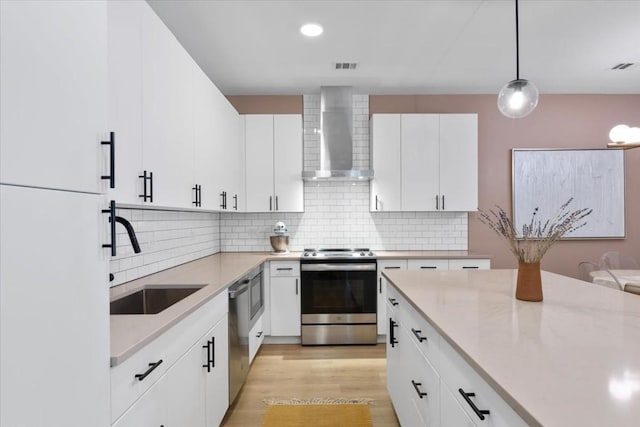 kitchen with stainless steel appliances, sink, pendant lighting, and white cabinets