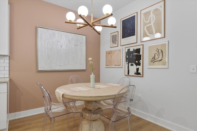 dining space with an inviting chandelier and light hardwood / wood-style flooring