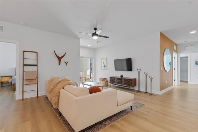 living room featuring ceiling fan and light wood-type flooring