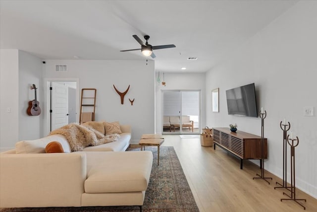 living room featuring light hardwood / wood-style flooring and ceiling fan