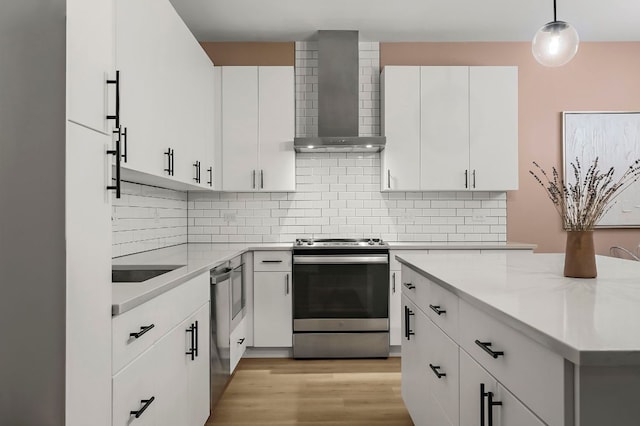 3101 Govalle Ave Unit 106, Austin, TX 78702 - kitchen with wall chimney range hood, decorative light fixtures, tasteful backsplash, white cabinets, and stainless steel appliances