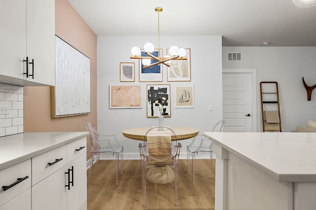 3101 Govalle Ave Unit 106, Austin, TX 78702 - dining space featuring an inviting chandelier, baseboards, wood finished floors, and visible vents