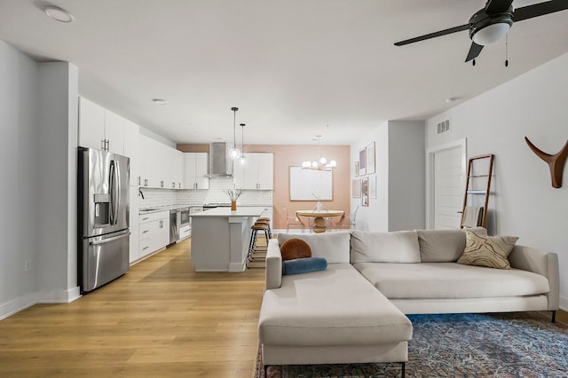 3101 Govalle Ave Unit 106, Austin, TX 78702 - living room featuring visible vents, light wood finished floors, and ceiling fan with notable chandelier