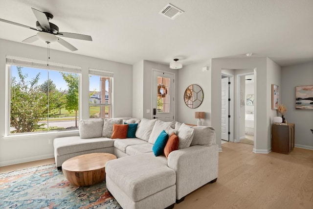 living room with ceiling fan and light wood-type flooring