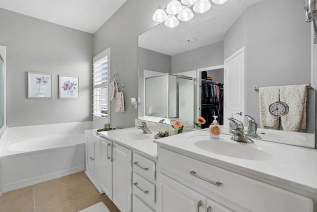 bathroom with an inviting chandelier, tile patterned floors, separate shower and tub, and vanity