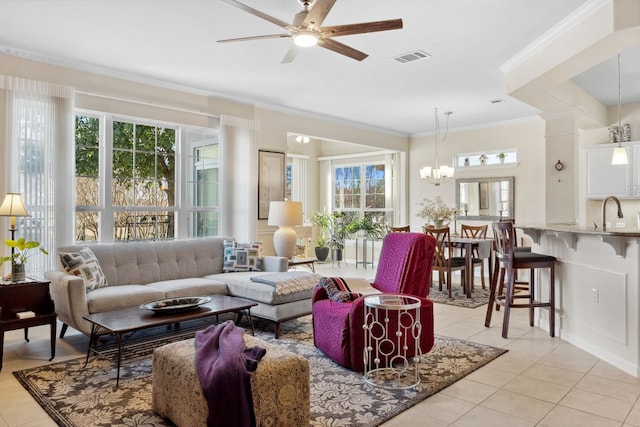 tiled living room featuring crown molding, sink, and ceiling fan with notable chandelier