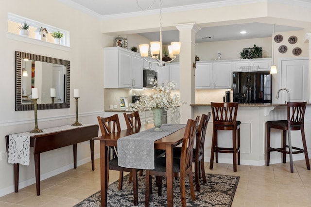 tiled dining area with crown molding, sink, and an inviting chandelier