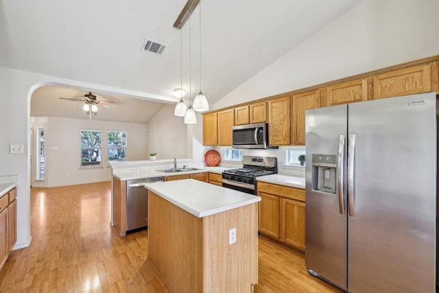 kitchen with a kitchen island, sink, hanging light fixtures, kitchen peninsula, and stainless steel appliances