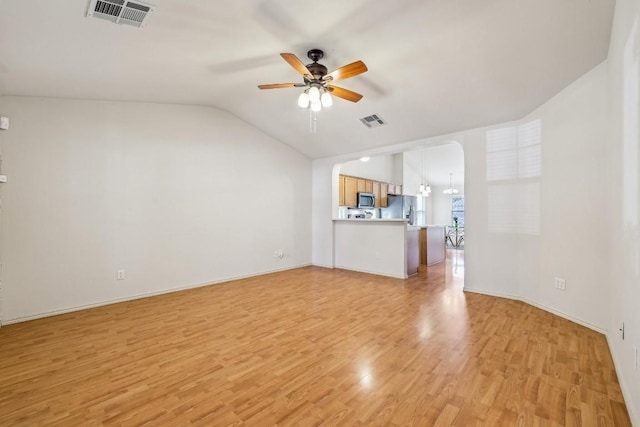 unfurnished living room with ceiling fan, vaulted ceiling, and light wood-type flooring