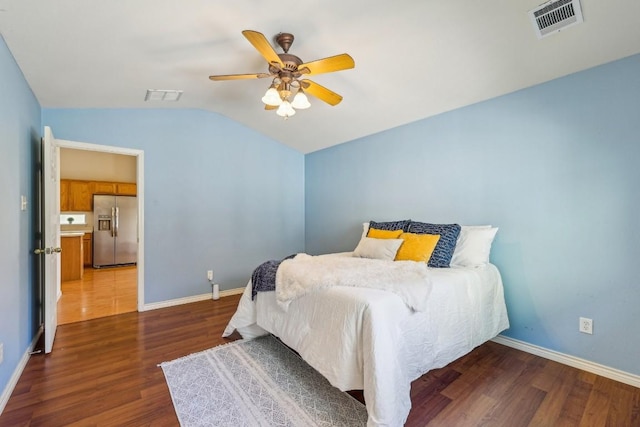 bedroom featuring dark wood-type flooring, stainless steel fridge, ceiling fan, and vaulted ceiling