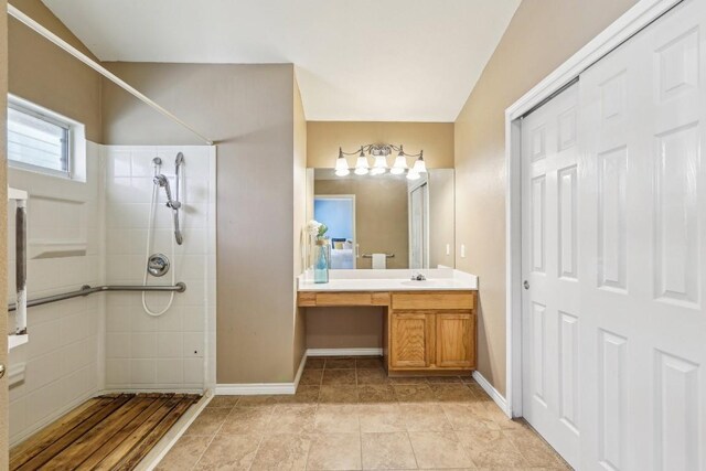 bathroom with vanity, a tile shower, and tile patterned floors