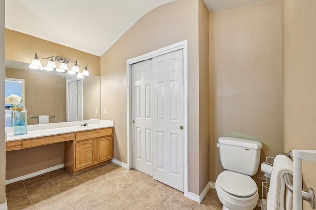 bathroom with vaulted ceiling, vanity, and toilet