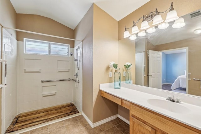 bathroom featuring tile patterned flooring, a shower, lofted ceiling, and vanity