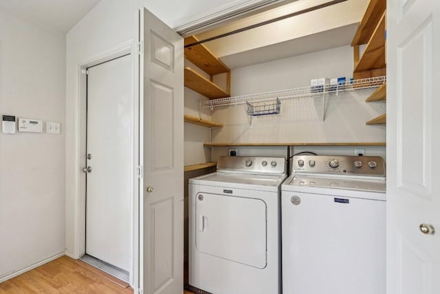 washroom with light hardwood / wood-style floors and washer and dryer