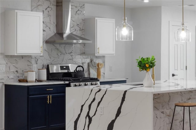 kitchen featuring white cabinets, hanging light fixtures, blue cabinetry, stainless steel range oven, and wall chimney exhaust hood