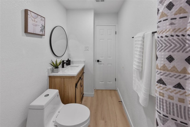 bathroom with hardwood / wood-style flooring, vanity, and toilet