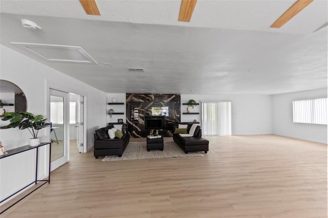 living room featuring a textured ceiling, ceiling fan, and light hardwood / wood-style flooring