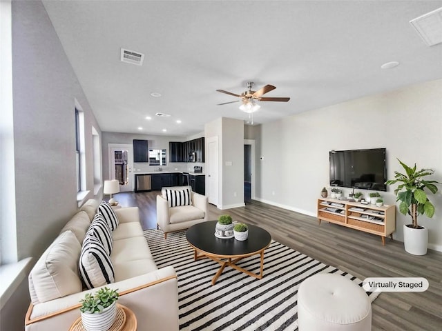 living room with dark wood-type flooring and ceiling fan