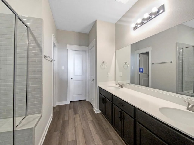 bathroom featuring vanity, hardwood / wood-style floors, and a tile shower