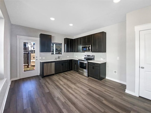 kitchen featuring hardwood / wood-style floors, dark brown cabinets, sink, and appliances with stainless steel finishes