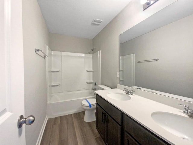 full bathroom featuring vanity, hardwood / wood-style floors, tub / shower combination, and toilet