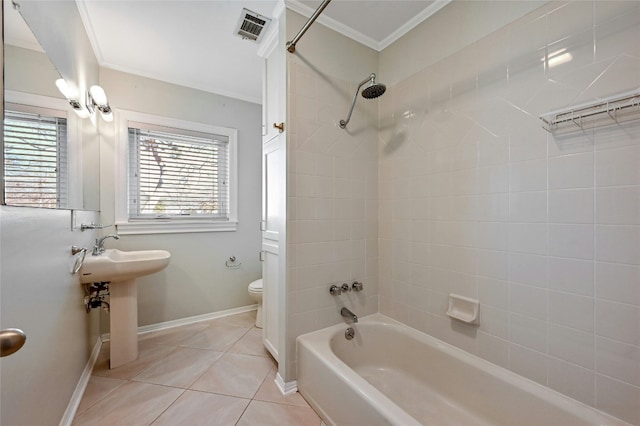 bathroom with crown molding, tiled shower / bath, toilet, and tile patterned flooring