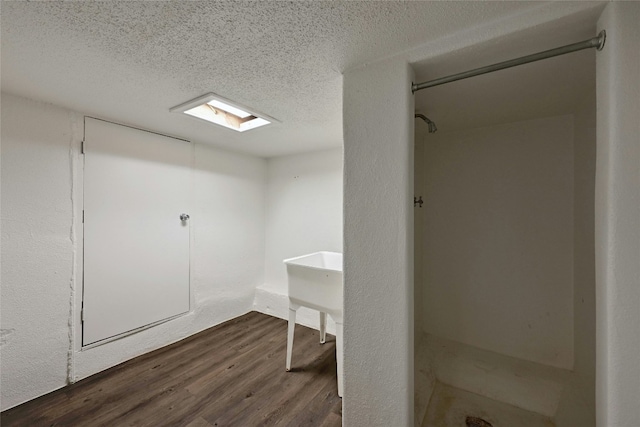 bathroom with hardwood / wood-style flooring and a textured ceiling