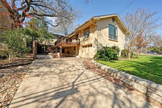 view of home's exterior featuring a garage, a lawn, and a deck