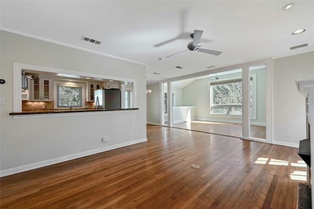 unfurnished living room with sink, hardwood / wood-style floors, and ceiling fan