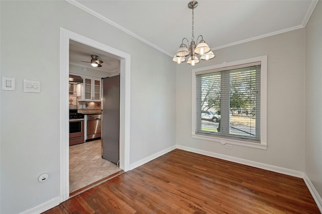 empty room with crown molding, light hardwood / wood-style flooring, and a notable chandelier