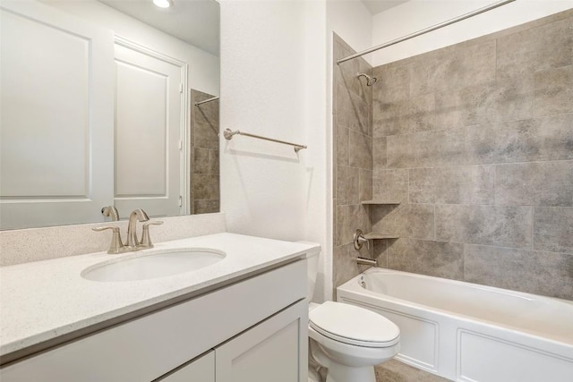 full bathroom with vanity, tiled shower / bath combo, and toilet