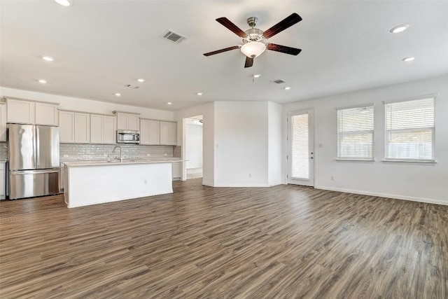 unfurnished living room featuring dark hardwood / wood-style flooring, sink, and ceiling fan