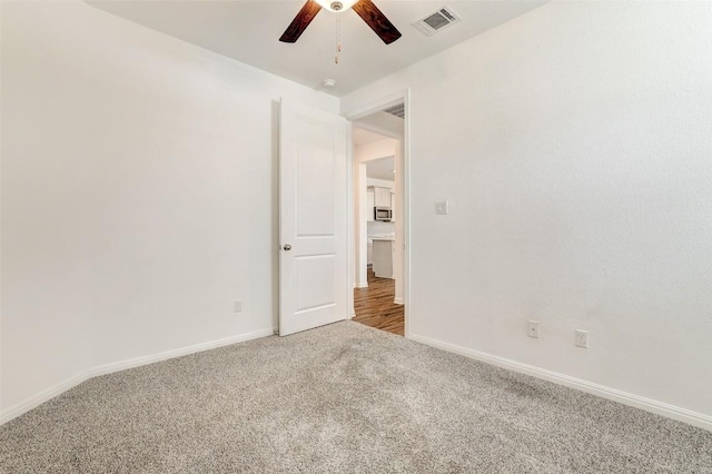 carpeted spare room featuring ceiling fan