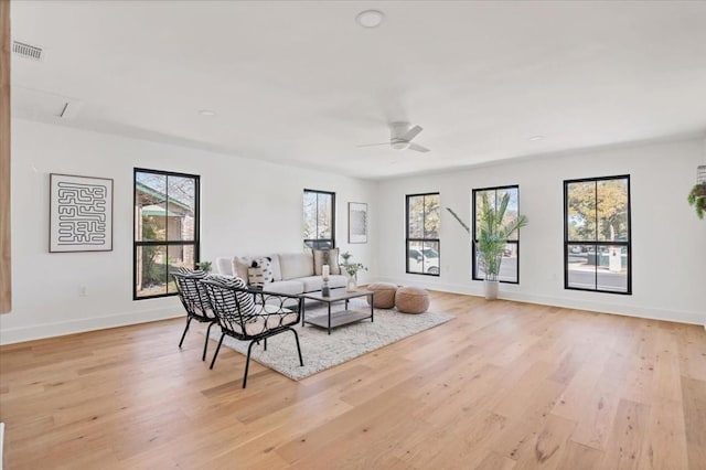 living room featuring plenty of natural light, ceiling fan, and light wood-type flooring