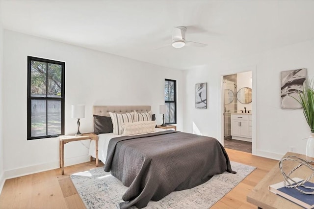 bedroom with ensuite bathroom, ceiling fan, and light hardwood / wood-style floors