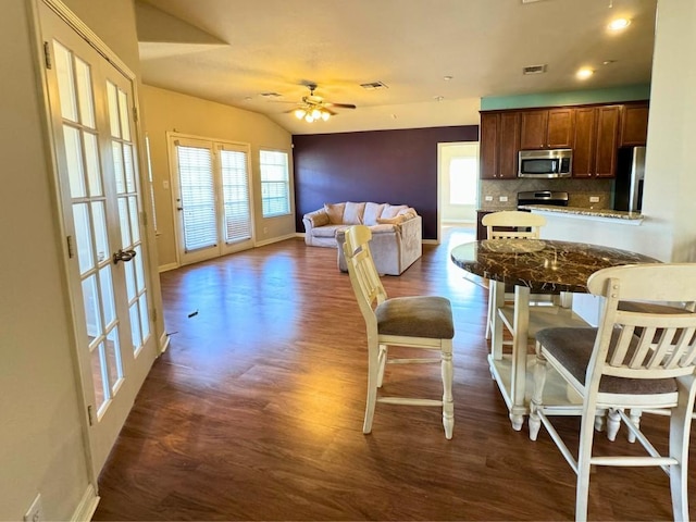 kitchen featuring tasteful backsplash, stainless steel appliances, dark hardwood / wood-style floors, and lofted ceiling