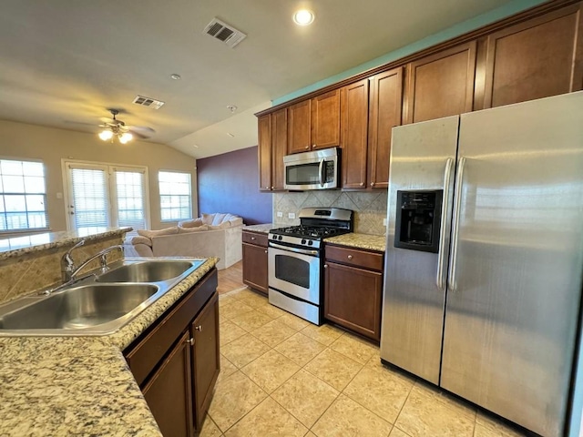 kitchen featuring sink, backsplash, stainless steel appliances, light tile patterned flooring, and vaulted ceiling