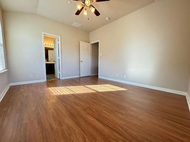 unfurnished bedroom with hardwood / wood-style flooring, ceiling fan, lofted ceiling, and ensuite bath