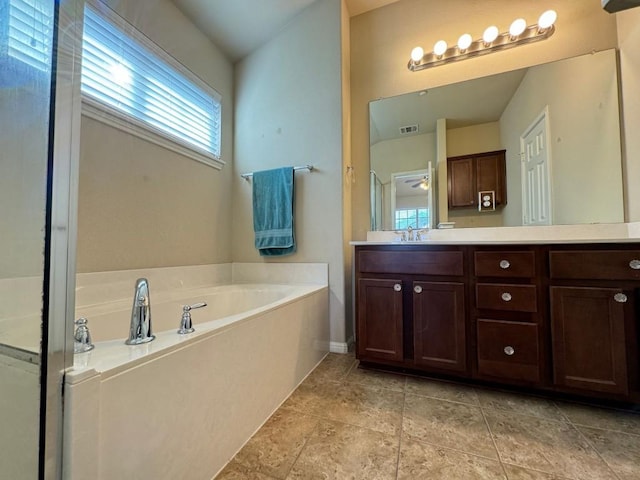 bathroom featuring vanity, tile patterned flooring, and a washtub