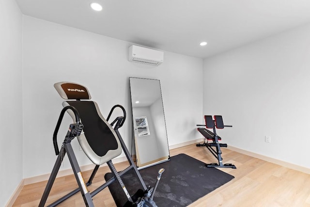 workout room featuring hardwood / wood-style flooring and a wall mounted AC