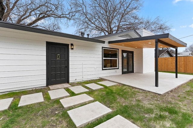 back of house with a patio area and a lawn