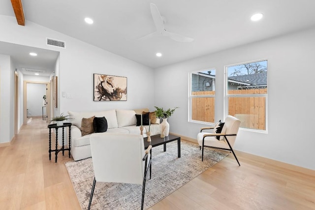 living room with vaulted ceiling with beams, ceiling fan, and light wood-type flooring