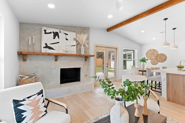 living room featuring a fireplace, lofted ceiling with beams, french doors, and light wood-type flooring