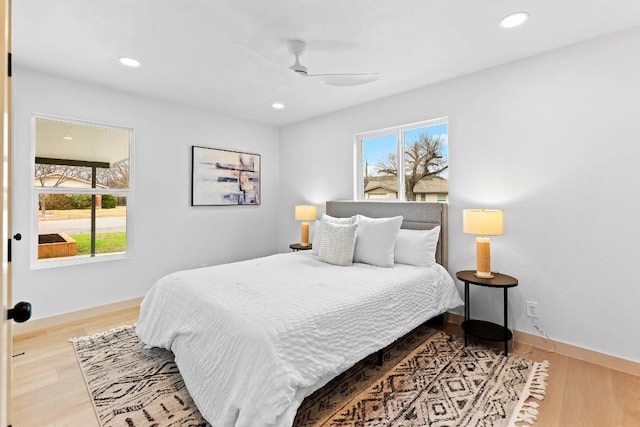 bedroom with ceiling fan, hardwood / wood-style floors, and multiple windows