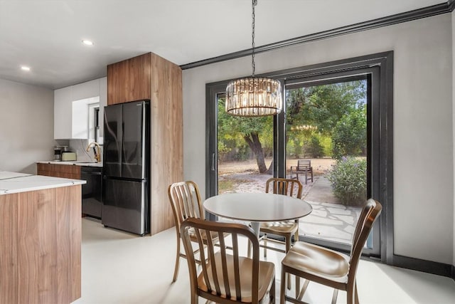 dining area featuring sink, a wealth of natural light, and a chandelier