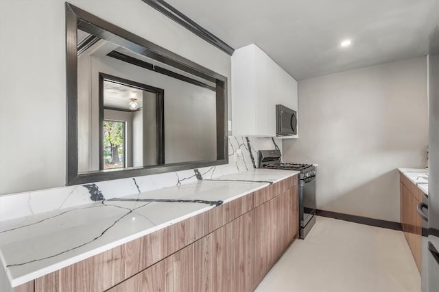 kitchen with tasteful backsplash, black range with gas cooktop, and light stone countertops