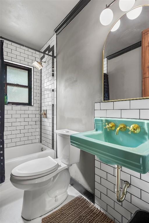 bathroom featuring tasteful backsplash, shower / bath combo, and toilet